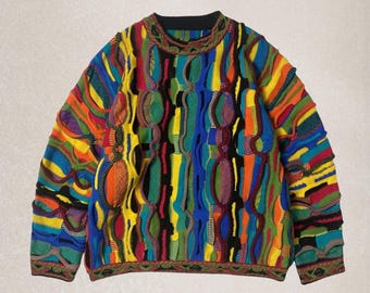 Op de afbeelding: Een veelkleurige trui met een ronde hals. De trui heeft een levendige mix van kleuren, waaronder blauw, geel, groen, oranje en rood. Het ontwerp bevat getextureerde, verhoogde elementen, waardoor een unieke visuele aantrekkingskracht ontstaat. De manchetten en de halslijn hebben een gedetailleerde afwerking.