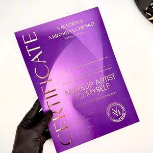 Peut inclure: Un certificat rectangulaire violet avec des lettres en feuille d'or. Le texte indique VIKTORIYA MIROSHNYCHENKO makeup artist, CERTIFICATE, MAKEUP ARTIST TO MYSELF et Instructor - Viktoriya Miroshnychenko, avec un logo circulaire et les initiales VM.