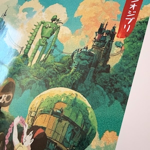 May include: A vibrant illustration depicting a green robot, a fortress, and a young woman with a floral garland. The artwork has a fantasy theme, with a blue sky and clouds in the background. Japanese text is visible.