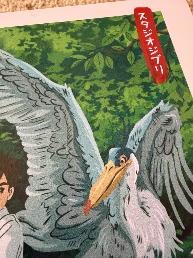 K&ouml;nnte beinhalten: Illustration eines gro&szlig;en Vogels mit ausgebreiteten Fl&uuml;geln, in Graut&ouml;nen, Blau und Beige. Der Vogel hat einen langen Schnabel und ist vor einem gr&uuml;nen Hintergrund aus Bl&auml;ttern platziert. Das Bild enth&auml;lt japanischen Text in einem roten Rechteck.