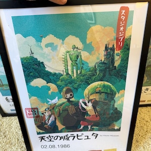 Puede incluir: Impresi&oacute;n art&iacute;stica enmarcada con una vibrante ilustraci&oacute;n de la pel&iacute;cula "El castillo en el cielo". La obra presenta un robot verde, personajes y texto japon&eacute;s. La impresi&oacute;n incluye la fecha 02.08.1986 y el nombre Hayao Miyazaki.