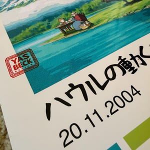 Op de afbeelding: Een poster met een sc&egrave;ne uit een animatiefilm, met een bergketen, water en een mechanische structuur op de achtergrond. Japanse tekst en de datum 20.11.2004 zijn ook zichtbaar.