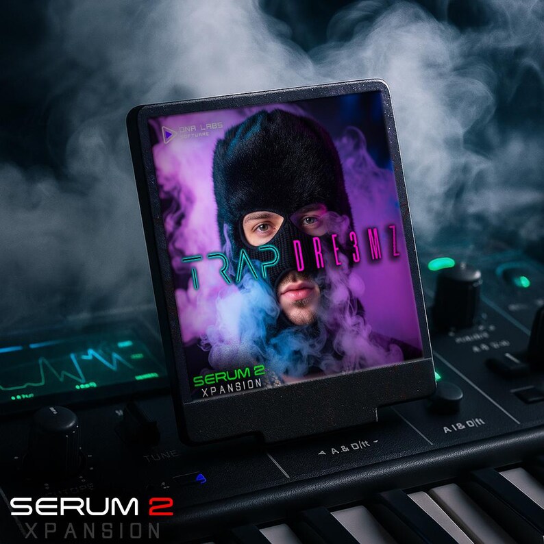 May include: A black electronic device displays a person wearing a black balaclava with the text "TRAP DRE3MZ". The device is on a keyboard with the text "SERUM 2 XPANSION". The background features purple and blue smoke.