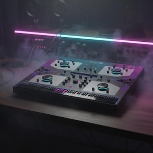 May include: A DJ mixing console with a keyboard and various knobs and controls. The console is black and silver, with blue and purple lighting. It sits on a wooden desk in a dimly lit studio, with a neon light above.