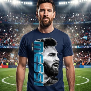 Puede incluir: Una camiseta de manga corta azul marino con un retrato en blanco y negro de Lionel Messi en la parte delantera. El texto "LIONEL" aparece en letras peque&ntilde;as sobre el gran gr&aacute;fico vertical "MESSI" en tonos azules junto al retrato.