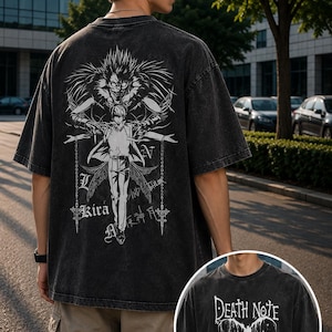 May include: A charcoal gray acid-wash t-shirt featuring a large white graphic on the back depicting a character with spiky hair and a figure with wings, with the text Kira. The front of the shirt displays the text Death Note in white lettering.