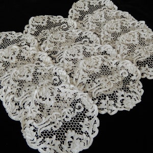 May include: A set of delicate, white lace doilies with intricate floral patterns. The doilies are made of a fine, lightweight material and have a soft, vintage feel.
