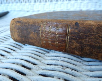 Könnte beinhalten: Ein braunes, ledergebundenes Buch mit goldener Beschriftung auf dem Rücken, die "BONAPARTE UND DIE KUNST UND DIE WISSENSCHAFTEN" lautet.
