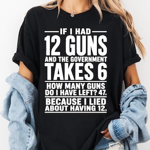 May include: A black short-sleeved t-shirt featuring white text that reads: IF I HAD 12 GUNS AND THE GOVERNMENT TAKES 6 HOW MANY GUNS DO I HAVE LEFT? 47. BECAUSE I LIED ABOUT HAVING 12. The shirt has a crew neckline and a relaxed fit with rolled sleeves.