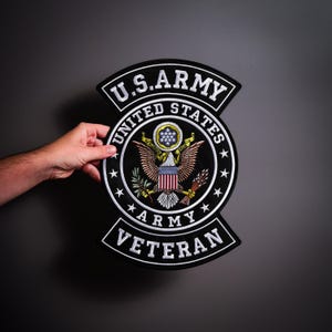 Op de afbeelding: Een grote, ronde geborduurde patch met het U.S. Army-embleem, voorzien van een adelaar, schild en sterren. De zwarte rand bevat de tekst U.S. ARMY bovenaan en VETERAN onderaan, met UNITED STATES ARMY in een cirkel geschreven.