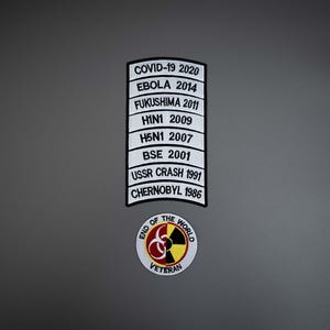May include: A rectangular patch with black text on a white background listing historical events including COVID-19 2020, EBOLA 2014, FUKUSHIMA 2011, H1N1 2009, H5N1 2007, BSE 2001, USSR CRASH 1991, and CHERNOBYL 1986, above a circular patch with a biohazard symbol.