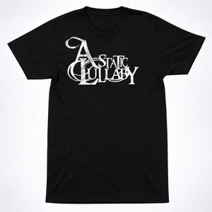 Könnte beinhalten: Schwarzes T-Shirt mit dem weißen Schriftzug "A Static Lullaby" in einer stilisierten, gotischen Schriftart. Das Shirt hat einen Rundhalsausschnitt und kurze Ärmel. Der Text ist mittig auf der Brust platziert.