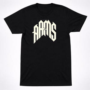 May include: Black t-shirt featuring the word "AAMS" in a stylized, off-white font. The text is arranged in a unique, geometric design, centered on the chest. The shirt has short sleeves and a crew neck.