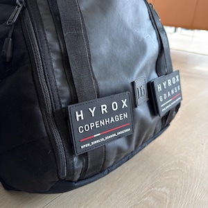 Soporte para parches HYROX para mochila DB Journey – Soporte para insignias con clip – Accesorio para gimnasio y competición
