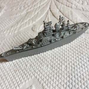 Sacapuntas de acorazado antiguo. Modelo de acorazado de acero inoxidable plateado con sacapuntas en la parte inferior. Adorno de oficina en miniatura.