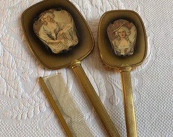Ensemble de commode vintage Art Neveau en laiton, miroir à main, brosse et peigne. Image d'une Française au dos d'un miroir et d'un pinceau. Poignées striées.