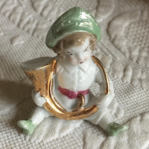 Vintage Tischkartenhalter Miniatur Porzellan Mädchen mit Waldhorn, sitzend mit Horn um den Hals gewickelt. Könnte ein kleiner Junge sein.