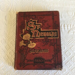 May include: A red book with gold lettering and illustrations. The title is "St. Nicholas Illustrated 1880, Part Two."