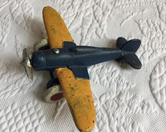 Vintage-Modellflugzeugfigur aus Gusseisen in Blau und Gelb mit drehbaren Rädern und Propeller.