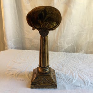 Perchero de madera de bronce hecho a mano con cojín de terciopelo dorado con ribete de hilo y adornos de bronce moldeado. Elegante pilar.