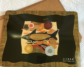 Tovagliette vintage Jijaka Australia in cartone, gialle e rosse su sfondo nero con retro in sughero. Decorate con pellicano, squalo, ornitorinco, varano, coccodrillo e tartaruga.