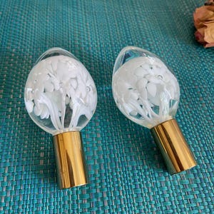 Vintage Lampenknöpfe aus mundgeblasenem klarem und weißem Glas mit Blumenformen im Inneren. 5 mm Öffnung im Sockel zum Festschrauben.