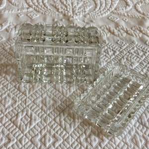 May include: A clear glass box with a geometric pattern. The box is open and the lid is sitting next to it.