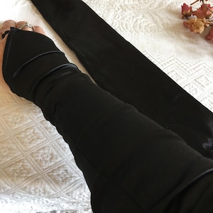 Gants sans doigts noirs vintage avec double volant et nœud au coude et élastique pour le doigt. Bien fait et idéal pour un bal ou une soirée.