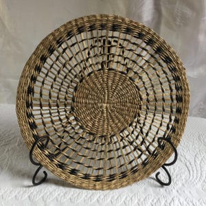 Tapete redondo de mimbre o hierba de estilo vintage para centro de mesa o para colgar en la pared. Colores claros y oscuros entrelazados.
