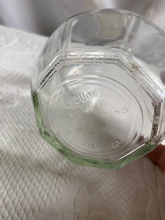 ビンテージの八角形の透明ガラス製酒瓶。コルクまたはストッパーは付属