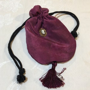 Handgemachte Seiden Reticule in Cranberry Overdyed Seide. Moosgrünes Seidenfutter. Schwarzer Kordelzug, Quaste. Kamee Oval auf Gold.