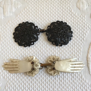 Puede incluir: Dos pares de cierres decorativos vintage. Un par es negro y presenta un diseño floral. El otro par es blanco y presenta un diseño de mano.