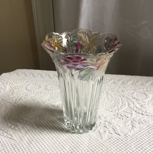 以下が含まれることがあります： フルーテッドデザインと波状の縁を持つ透明なガラスの花瓶。花瓶は、緑、紫、黄色の色合いのブドウの蔓模様で飾られています。