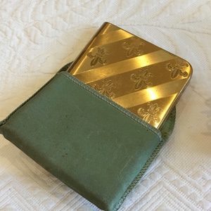 Vintage Elgin American Compact Con Diseños Fleur de Lis en rayas diagonales en metal. Apertura de puerta doble. Todavía tiene polvo y puff.