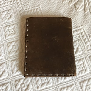 Vintage marrón cuero cartera pequeña. Monedero de tarjeta de crédito Mans, espacio para efectivo y un par de fotos. Costura decorativa a mano alrededor del borde.