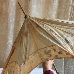 Parasol/parapluie ancien. Parasol en coton et bois. Aspect de fil tiré là où les tissus changent à la frontière. Besoin d&#39;une réparation.