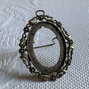 Victorian Gold Oval Metal Ornate Frame. Swirling and Floral Designs with Openwork and Ring at Top to Hang. No Glass in Frame.