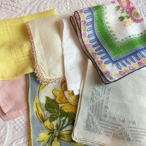 Puede incluir: Una colección de pañuelos vintage en varios colores y patrones. El surtido incluye un pañuelo amarillo, rosa y blanco, junto con otros con diseños florales y geométricos. Algunos tienen detalles de encaje o bordados.