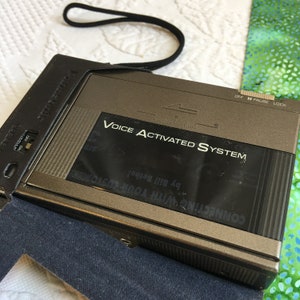 Vintage Sprachaktivierter Systemrecorder von Panasonic mit Trageriemen in einer Schutztasche aus simuliertem Leder.