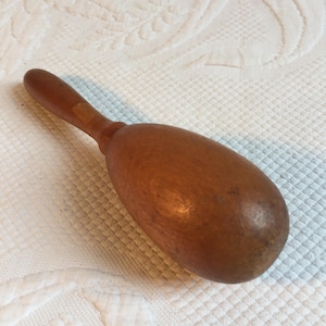 Puede incluir: Un muddler de madera con un mango largo y una cabeza de forma ovalada. El muddler está hecho de madera de color marrón claro y tiene un acabado liso y pulido. Está diseñado para mezclar ingredientes en cócteles u otras bebidas.