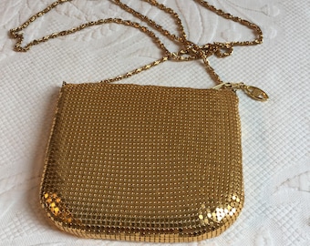 Monedero pequeño vintage de malla dorada con correa de cadena dorada. Cierre de cremallera y forro de satén dorado.