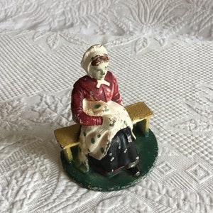 Vintage Cast Iron Doorstop or Bookend. Amish Lady Sewing Sitting on a Bench. Heavy and Charming Kitchen Bookend or Doorstop.