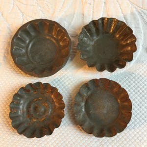 Antik 4 verschiedene alte Metall Tarteformen. Geriffelte Seiten, eine mit flacher Kante und 3 mit unteren Ringen. Vier ähnlich Große Tarteformen.
