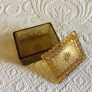 Bocal vintage en verre doré pour commode. Texturé avec des étoiles, des diamants, des fleurs et des vignes. Beau bocal pour commode ambré. Rectangulaire.