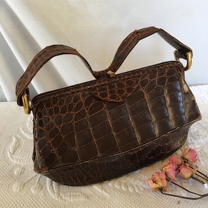 Vintage Alligator Leder Geldbörse mit Klappverschluss. Oberer Griff. 5 Innentaschen mit einem Reißverschluss. Innenfutter aus reinem Leder.
