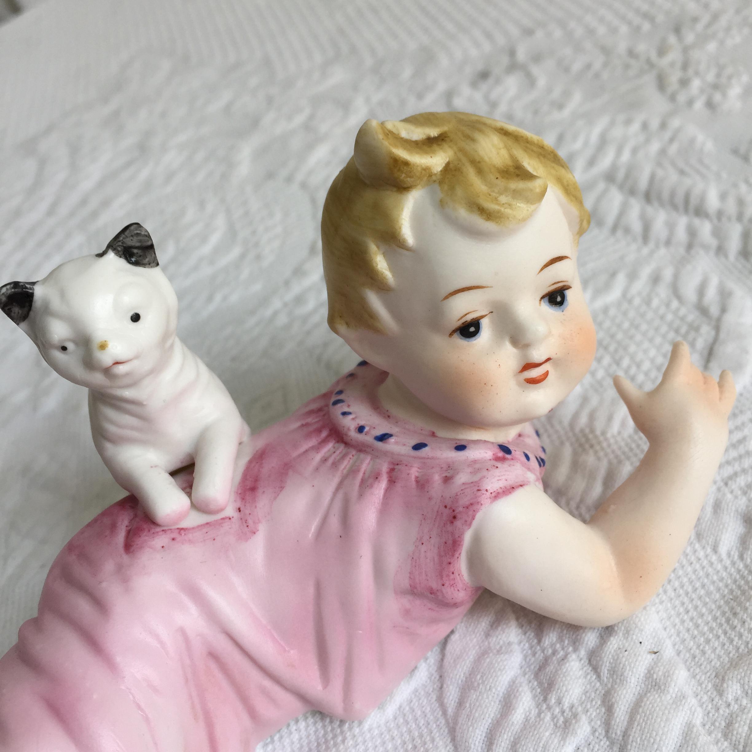 ヴィンテージ磁器の赤ちゃんと猫。赤ちゃんがうつ伏せになり、猫が