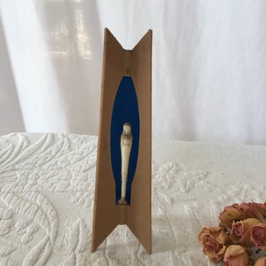 Vintage Tall Thin Madonna. Contemporary Madonna Display in Wood Grain Plastic Display With Navy Blue Background.