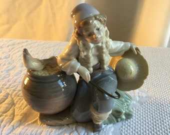 Figura de porcelana Lladró vintage de 1990 de niño con bastón y sombrero apoyado en una olla grande con una paloma. Figura de Natividad. Maravilloso elegante.