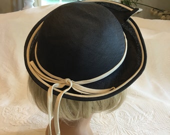 Vintage jaren 1950 blauwe en witte matroos stijl hoed. Omgeslagen asymmetrische rand met wit koord op blauw, geribde hoedenband en strik. Charmant.