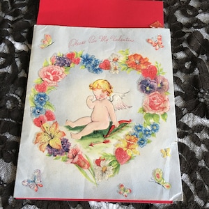 Vintage 1950er Jahre Doubl-Glo Valentinskarte mit hellem Kugelperlen-Glitzer. Amor weint im Blumenherz. Es war mit Love Daddy signiert.